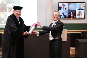Wim van den Bouwhuijsen (rechts) krijgt zijn doctorsbuil uit handen van promotor Jos Lichtenberg. Foto | Photodette / TU/e