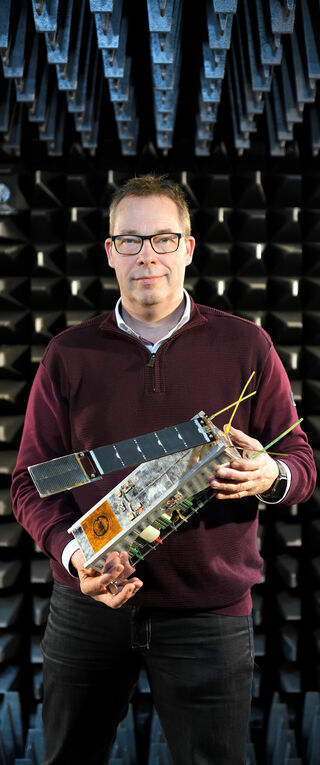 Mark Bentum with a nano-satellite. Photo | Bart van Overbeeke