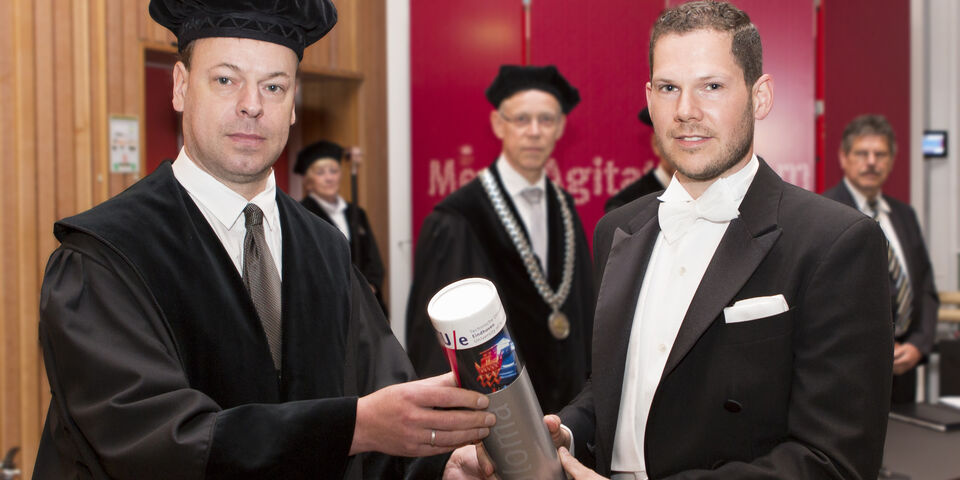 Rick Kramer (r) krijgt zijn bul uit handen van hoogleraar Bert Blocken. Foto: Arne Olivier.